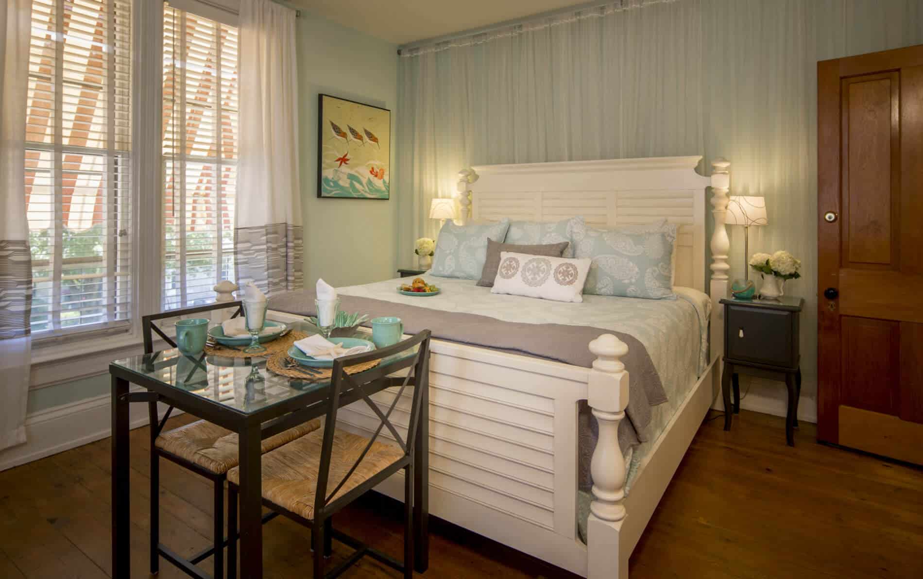 Beadroom with white bed and table.